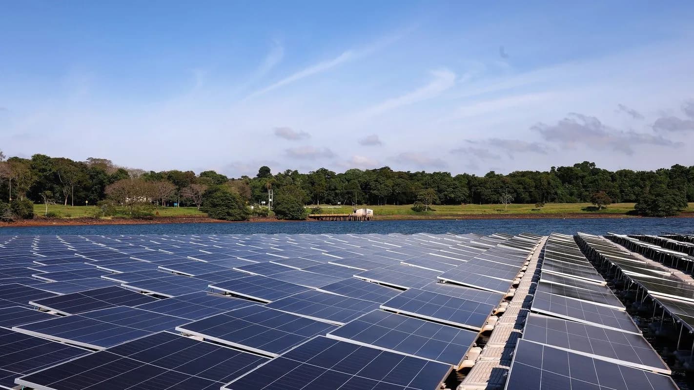 Usina solar fotovoltaica flutuante em reservatório, com painéis solares sob céu ensolarado