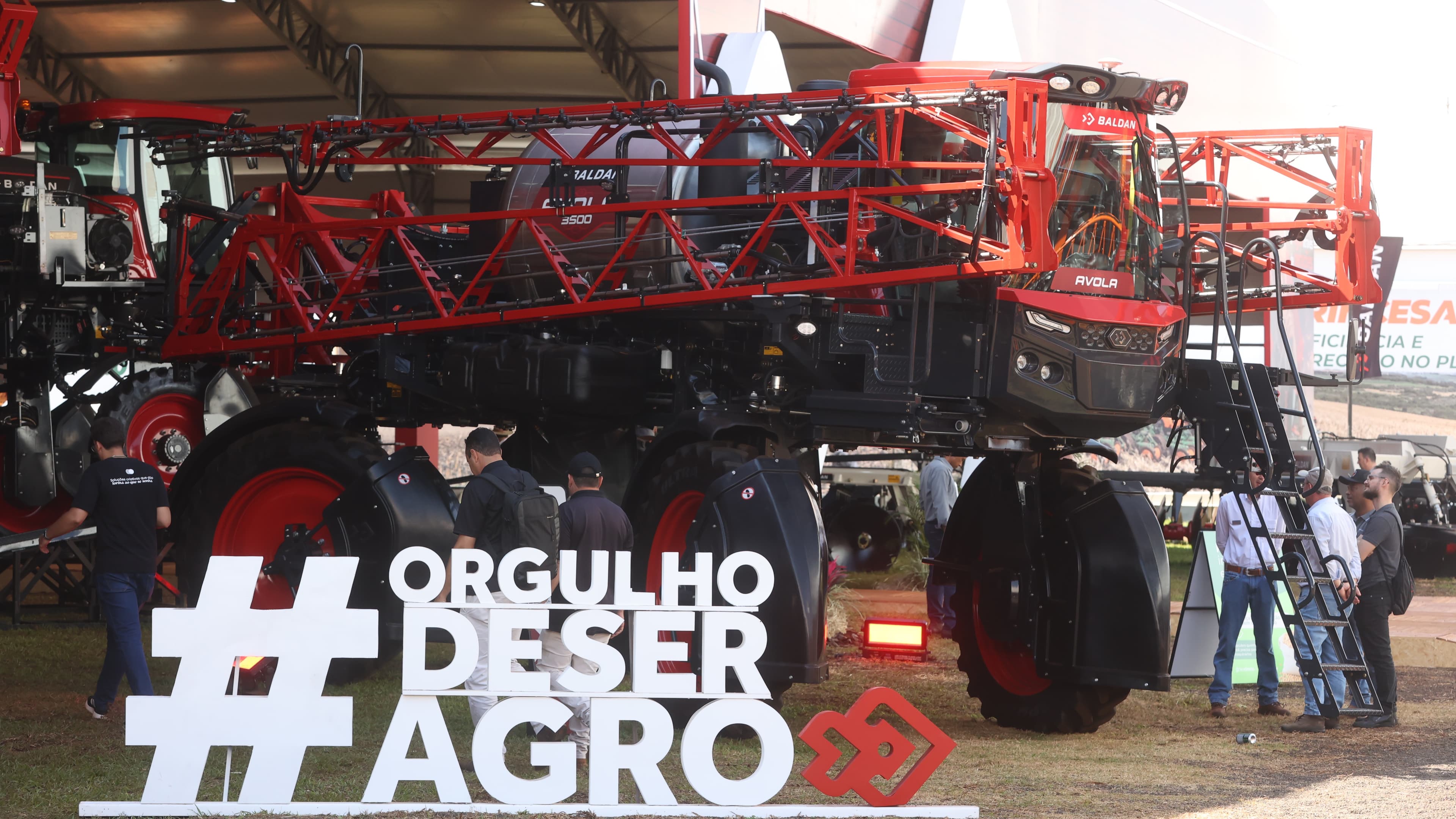 Máquina agrícola pulverizadora em exposição na Agrishow 2026, em Ribeirão Preto, com visitantes ao redor