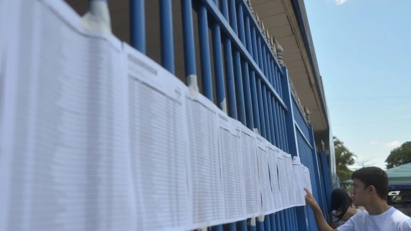 Candidato confere lista de sala afixada em portão de local de prova (foto de arquivo, ilustrativa)
