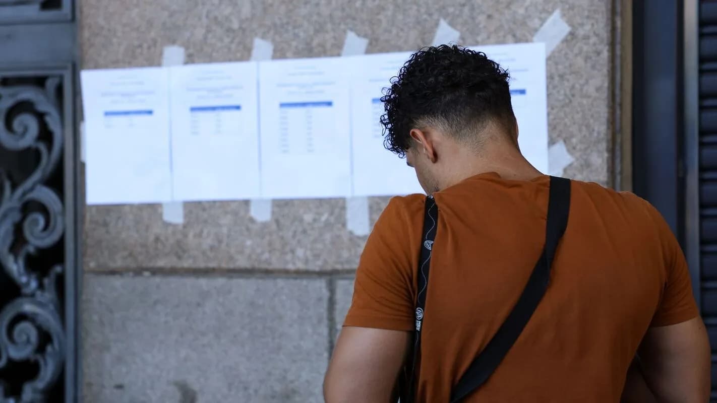 Candidato consulta lista de resultado de concurso afixada em parede, foto de arquivo ilustrativa