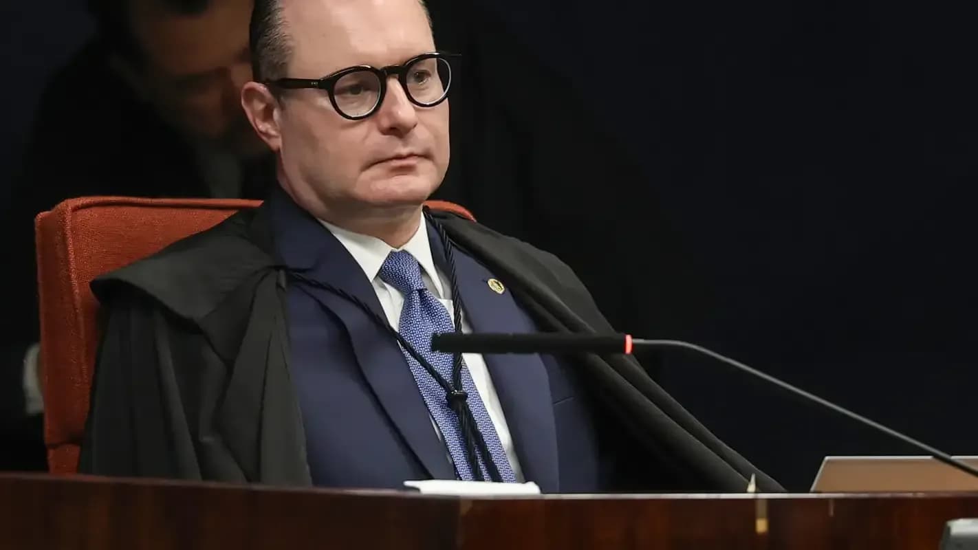 Ministro Cristiano Zanin sentado à mesa de sessão do STF, de toga, olhando para o lado