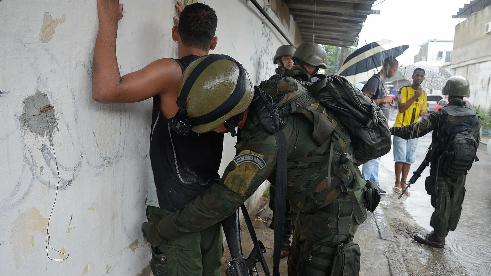 Agente de segurança revista suspeito durante operação policial no Rio de Janeiro