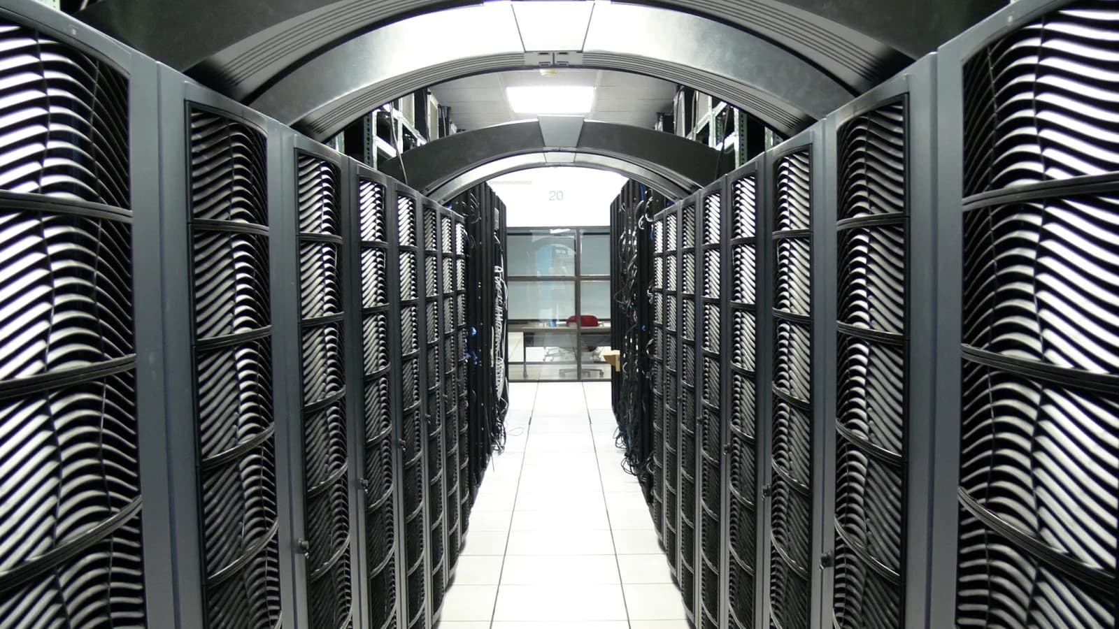 Corredor de servidores de um data center, com racks de computadores alinhados dos dois lados
