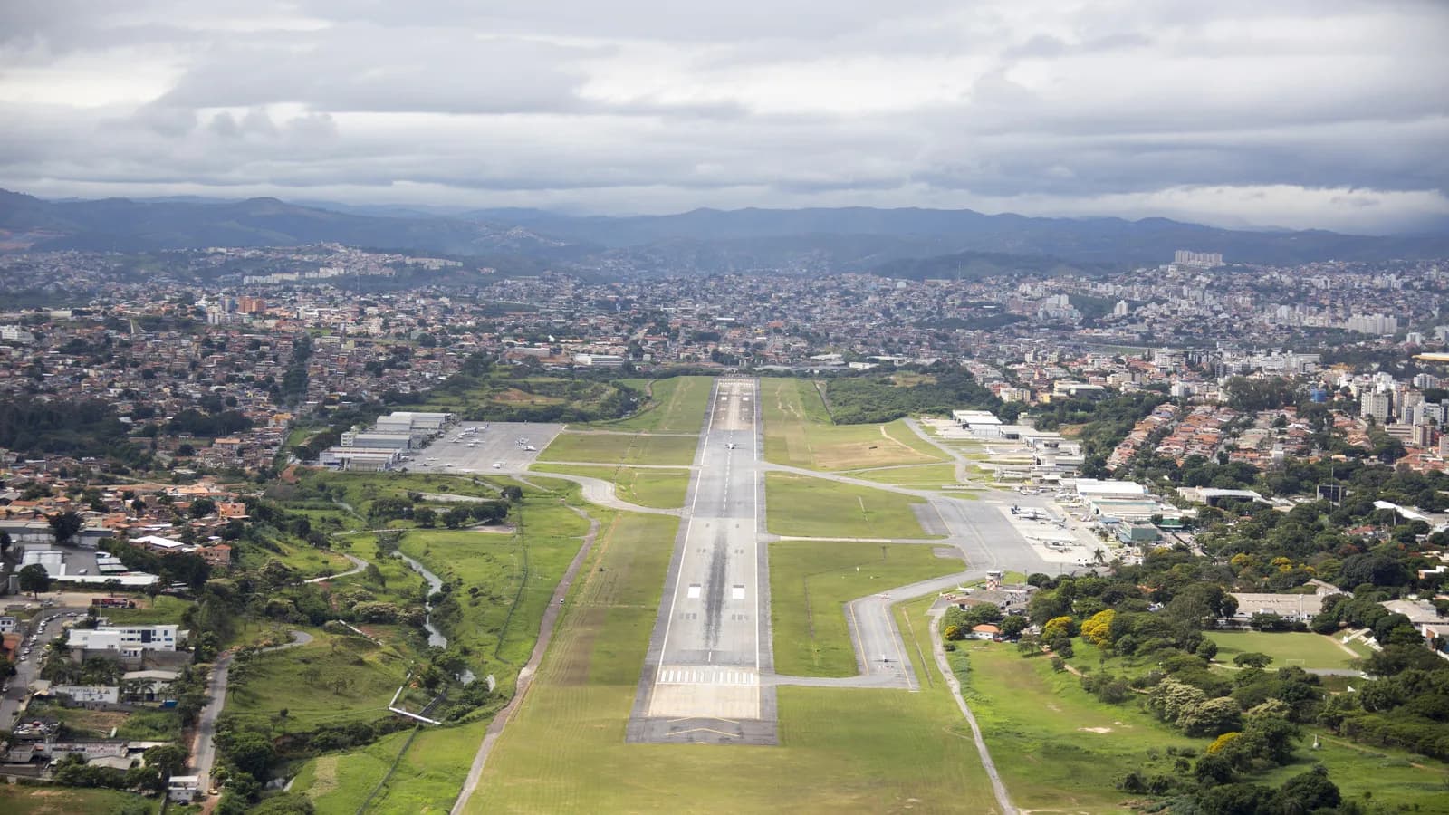 Vista aérea do Aeroporto da Pampulha, em Belo Horizonte, com pista e cidade ao fundo
