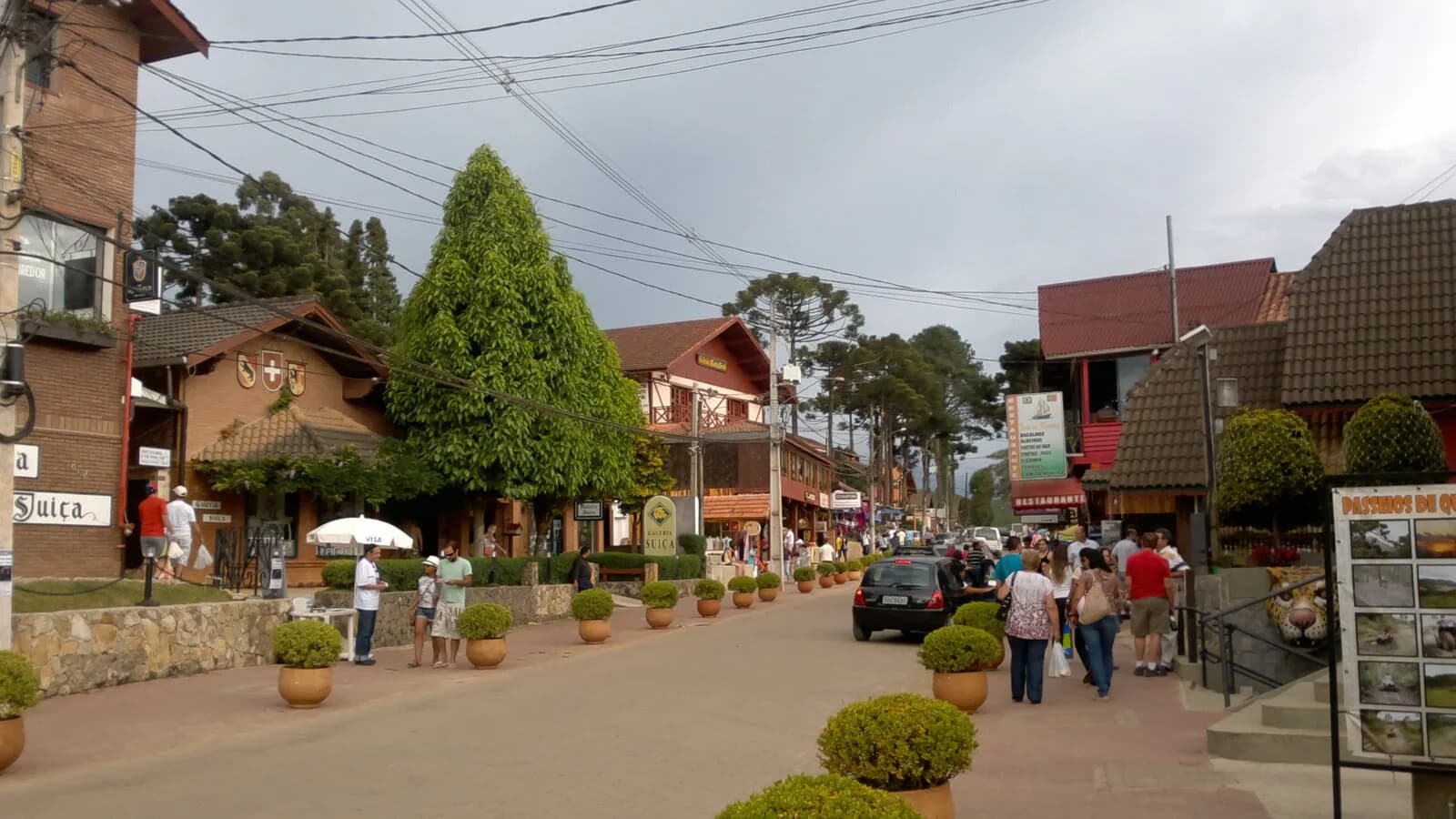 Rua principal de Monte Verde, distrito de Camanducaia (MG), com casas de estilo alpino e turistas caminhando