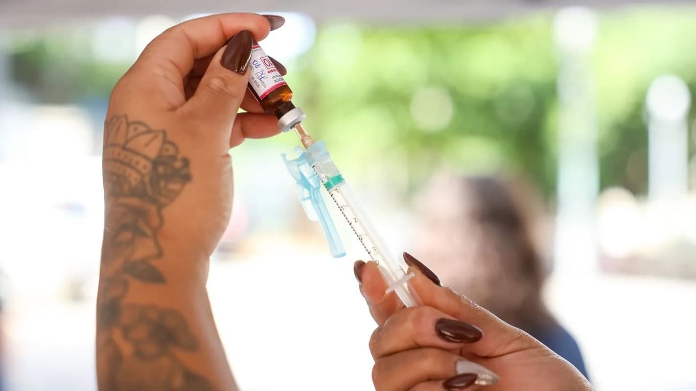 Profissional de saúde prepara dose de vacina em seringa a partir de frasco, em campanha de vacinação (foto de arquivo, ilustrativa)