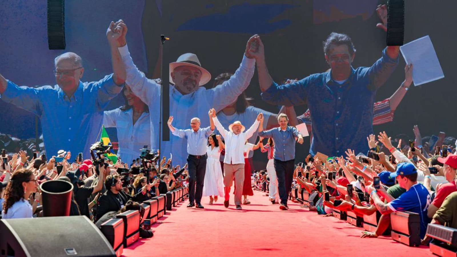 Fernando Haddad caminha ao lado do presidente Lula em tapete vermelho cercado por multidão, durante ato de lançamento de campanha no Estádio Vila Euclides, em São Bernardo do Campo