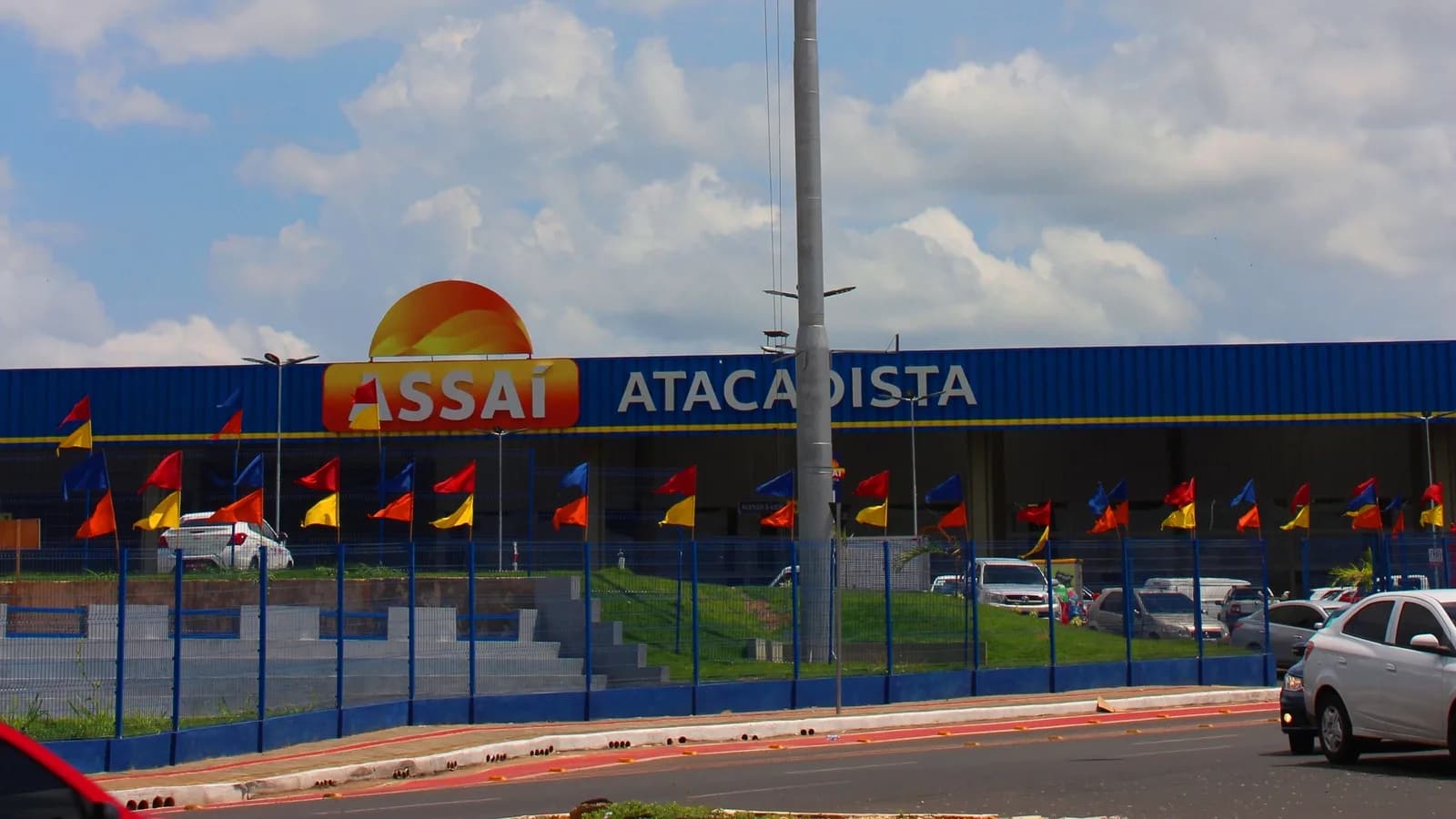 Fachada de uma loja do Assaí Atacadista com estacionamento e carros