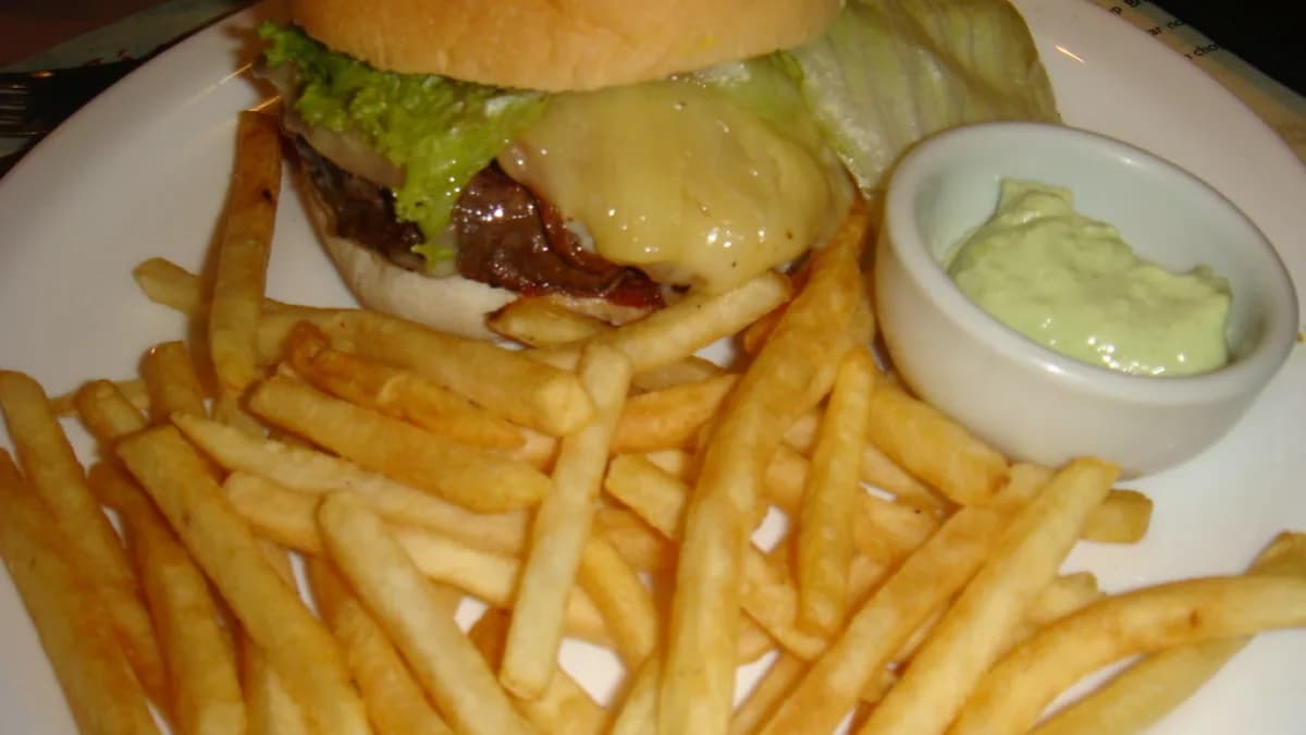 Hambúrguer com batatas fritas e molho servido em potinho individual