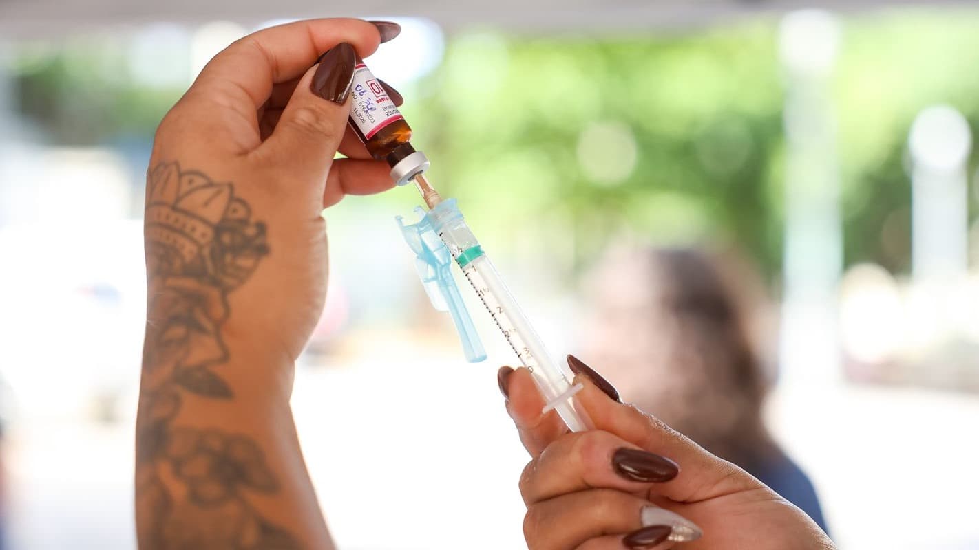 Profissional de saúde prepara dose da vacina tríplice viral em seringa, foto de arquivo de campanha de vacinação