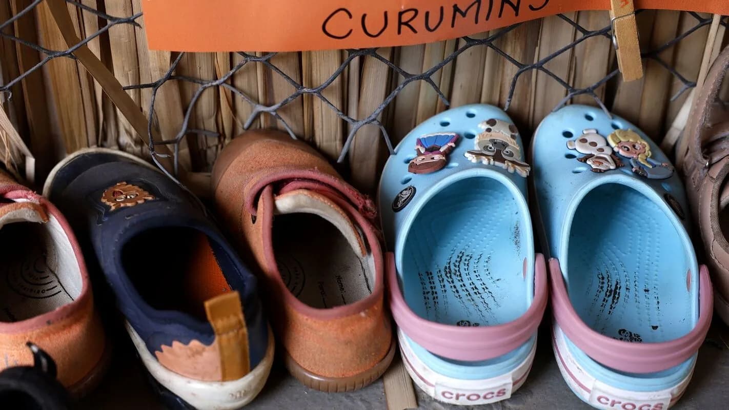 Calçados infantis organizados na entrada de uma creche, ilustrando o universo da educação infantil
