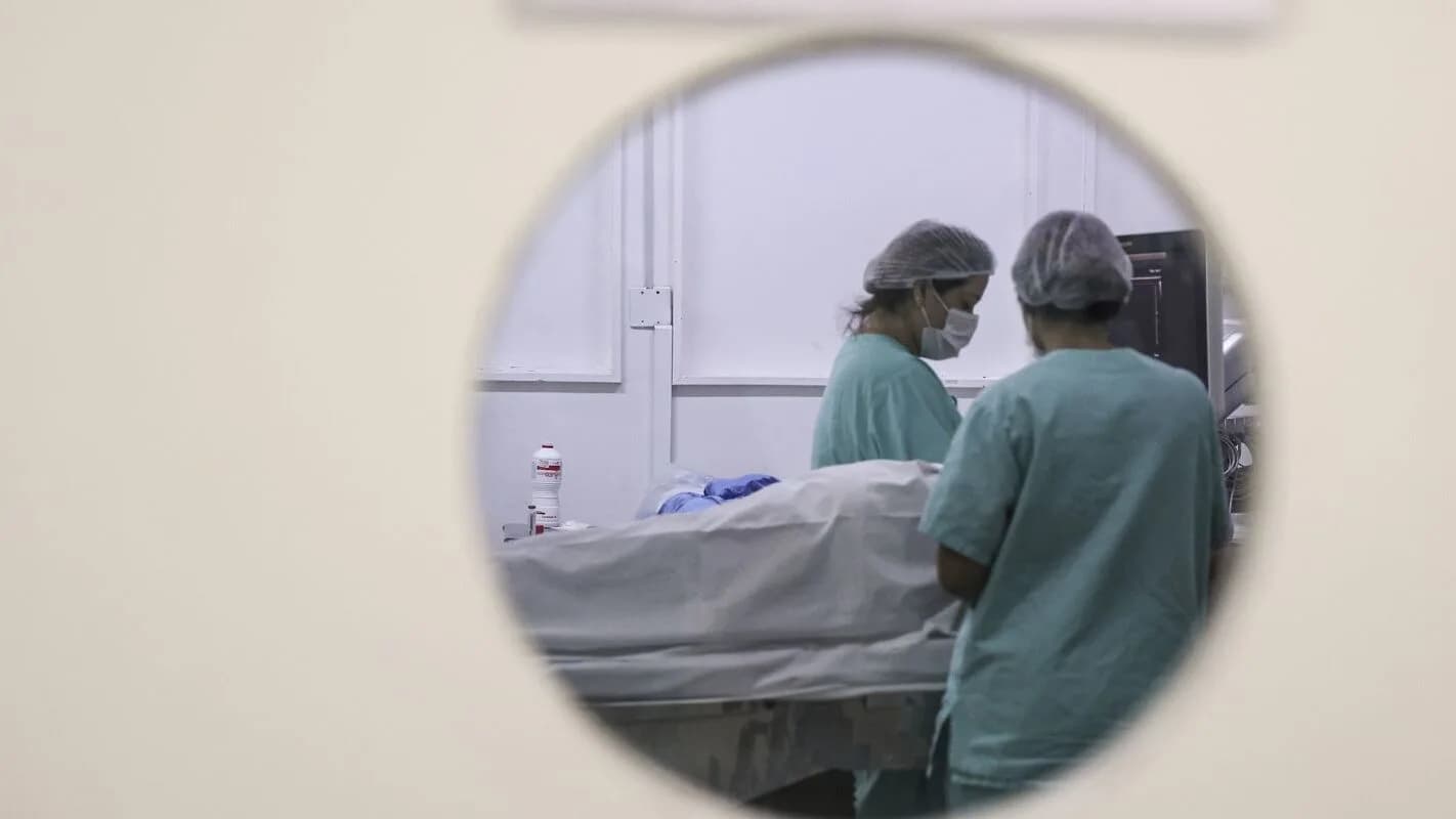 Profissionais de saúde atendem paciente em hospital durante mutirão médico