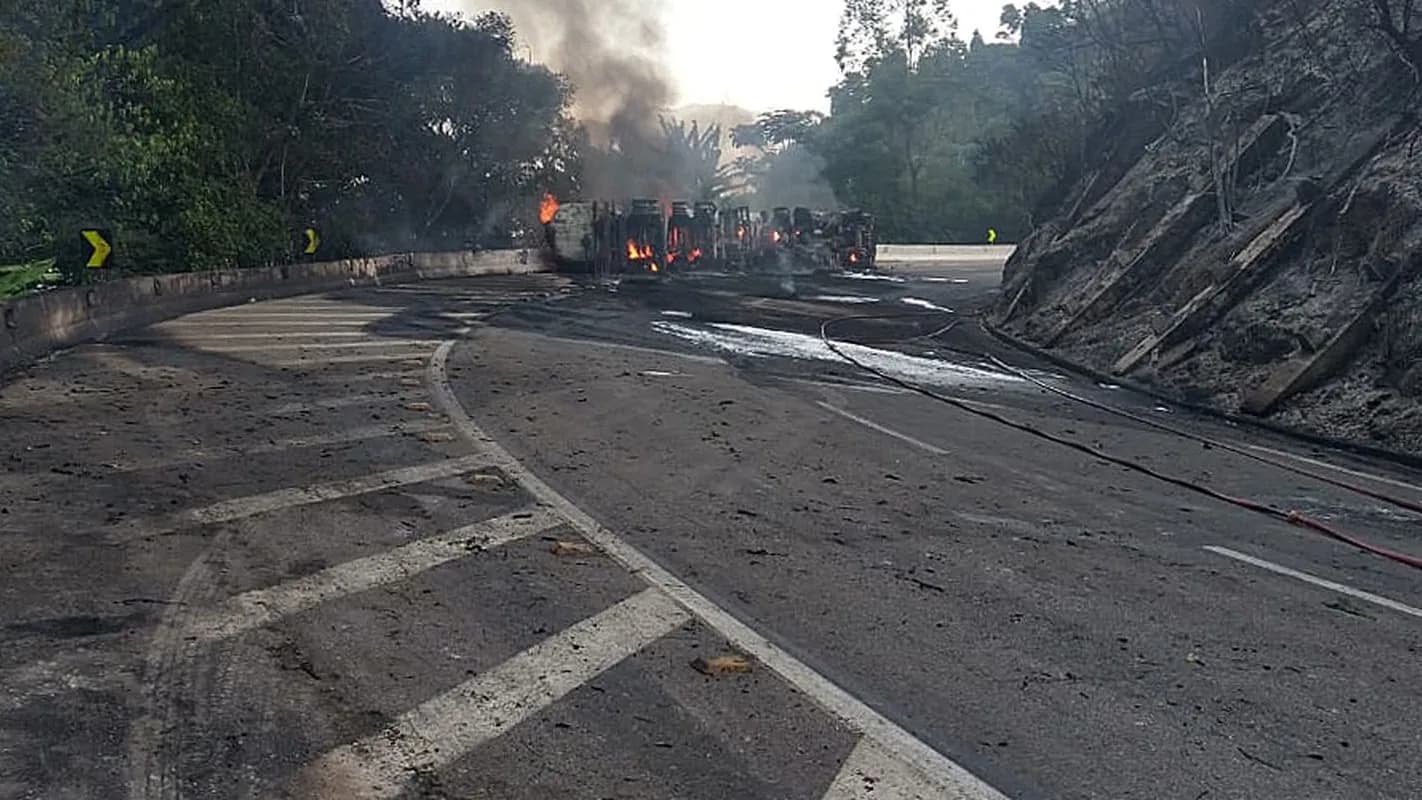 Imagem de arquivo mostra veículos em chamas interditando pista da BR-040 após outro acidente, com fumaça densa subindo entre a vegetação