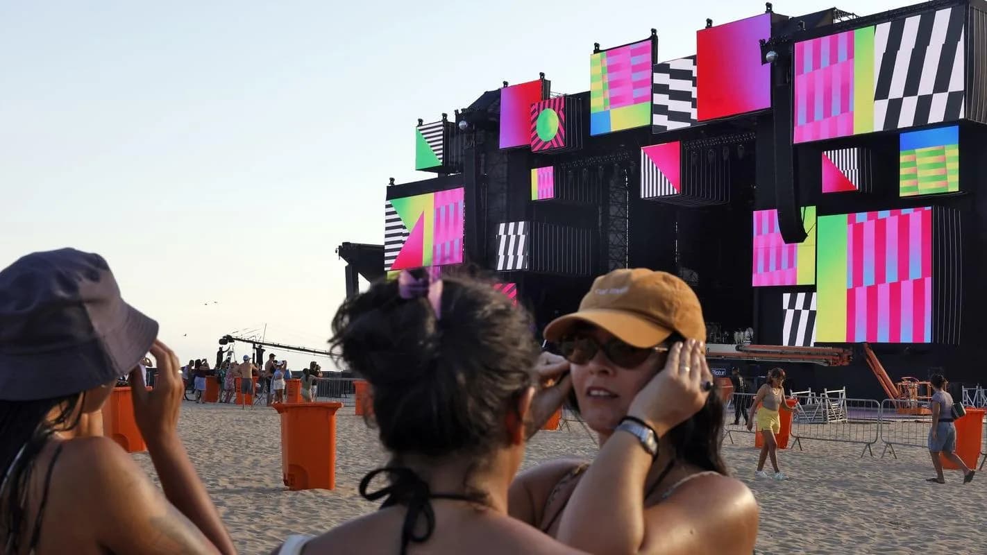 Turistas fotografam o palco montado na praia de Copacabana para a festa de Réveillon