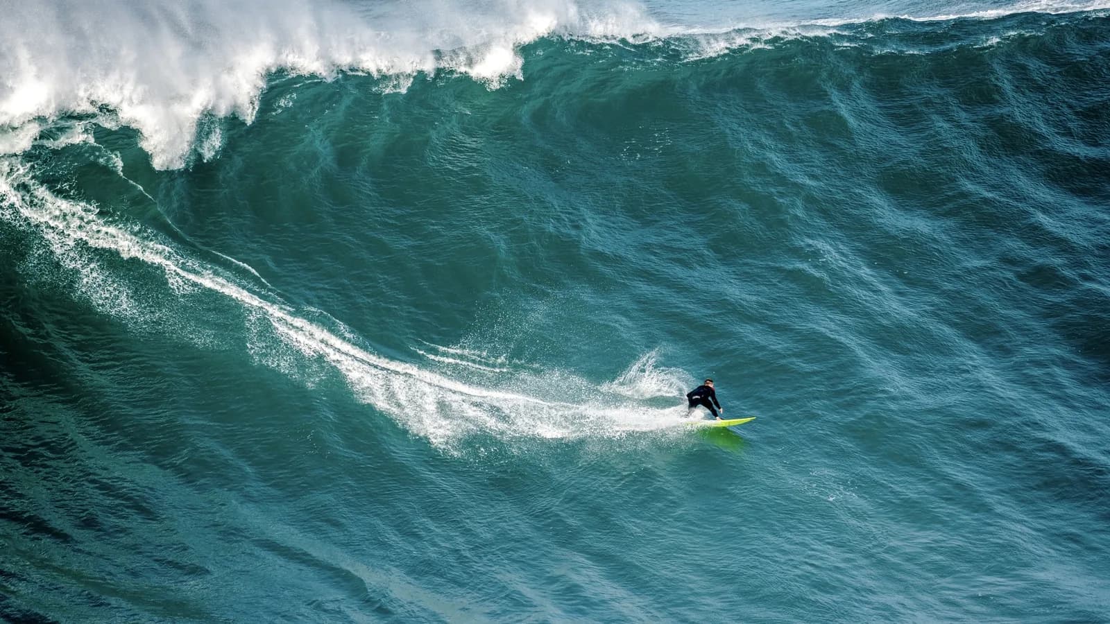 Surfista enfrenta onda gigante na Praia do Norte, em Nazaré, Portugal