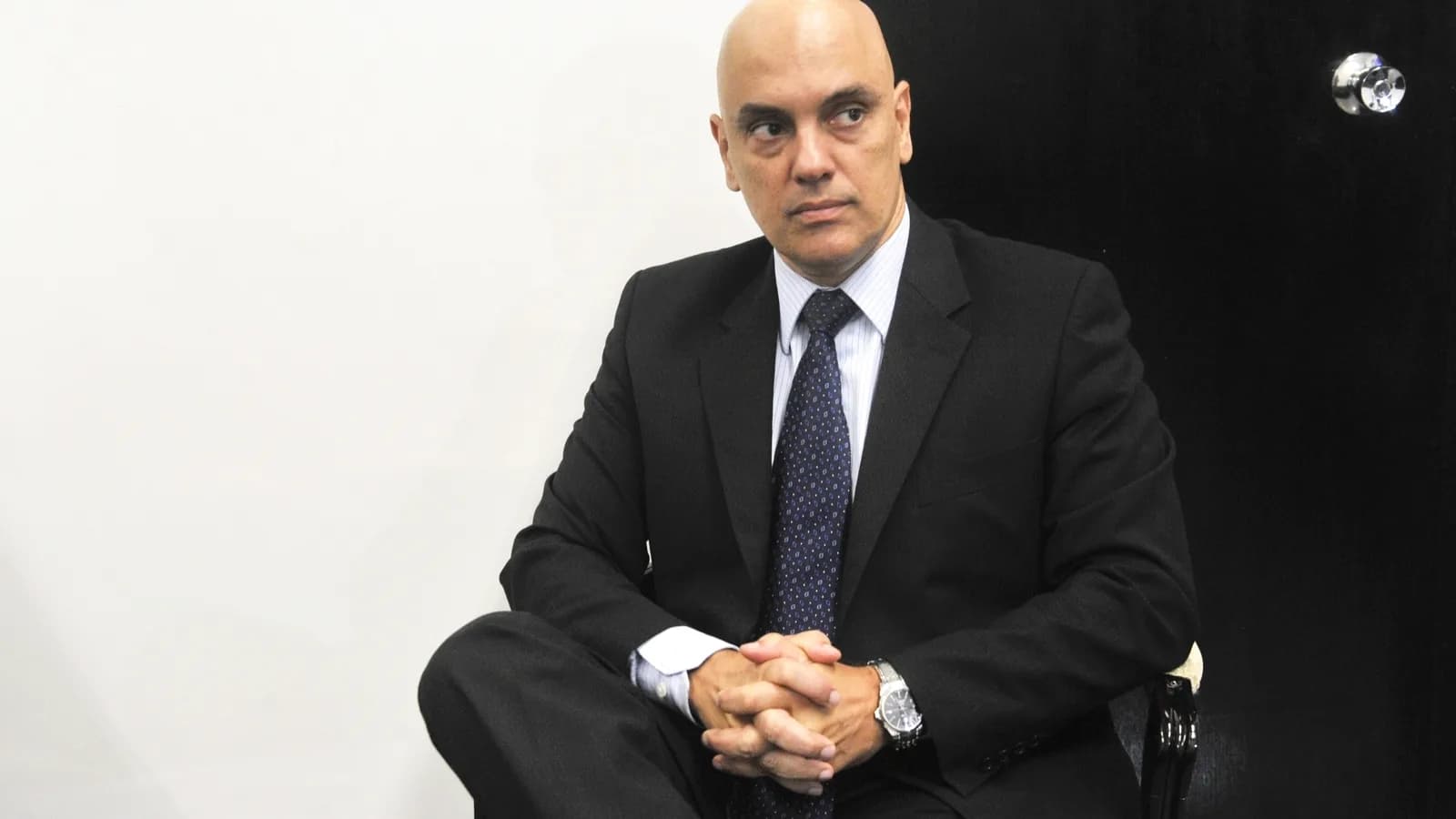 O ministro Alexandre de Moraes sentado, de terno escuro, em foto de arquivo