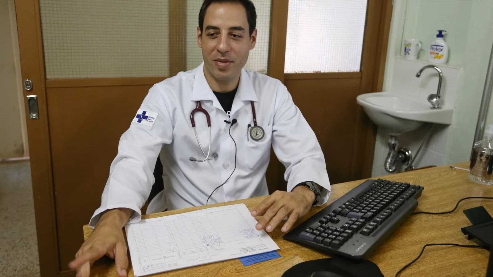 Médico de jaleco branco e estetoscópio atende em consultório (foto de arquivo do programa Mais Médicos)