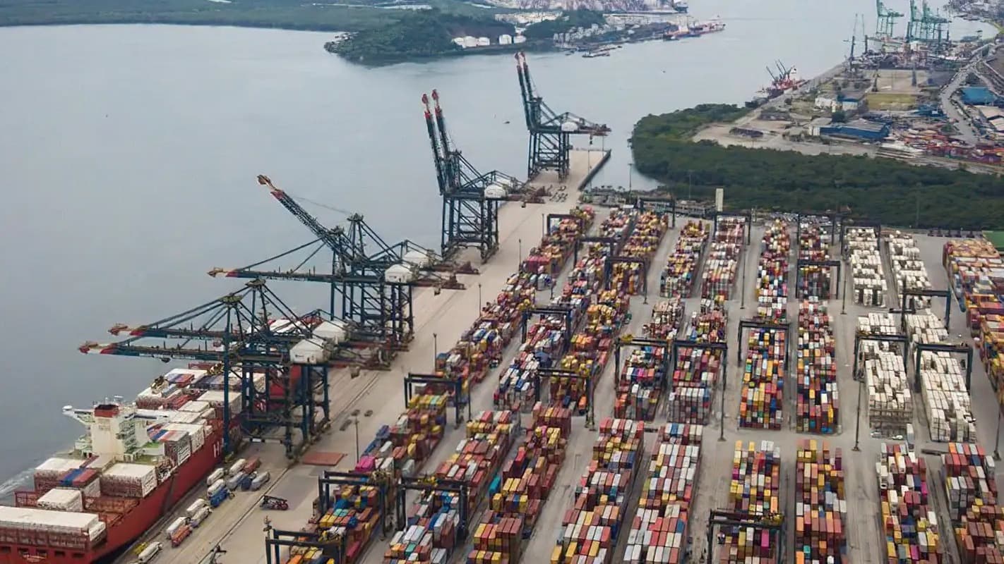 Vista aérea do Porto de Santos com navio atracado e pátio de contêineres