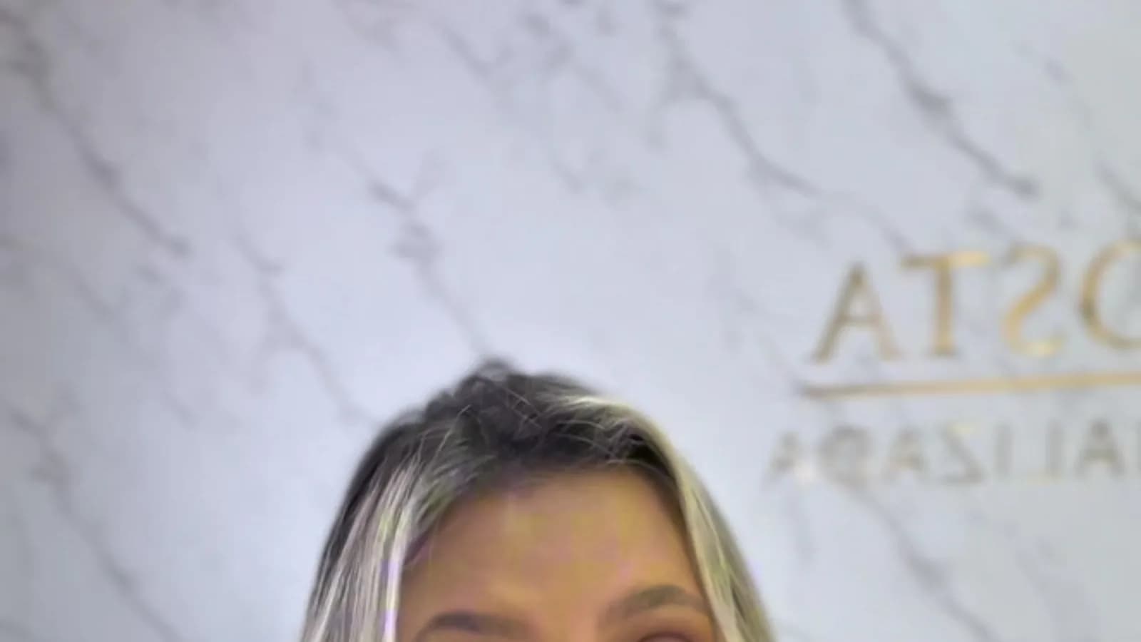 A advogada Isabela Costa fala em vídeo, com um fundo de mármore e uma legenda mostrando seu nome e a profissão.