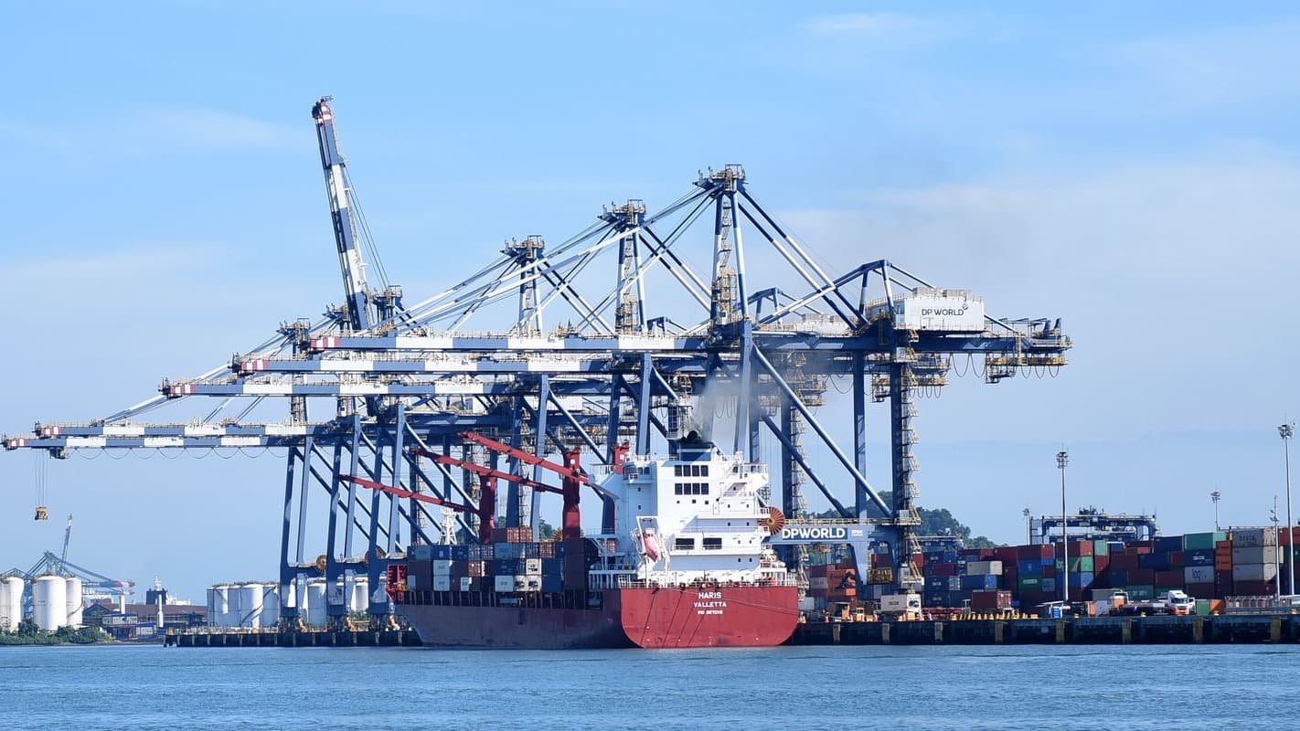 Navio cargueiro atracado sob guindastes de contêineres no Porto de Santos