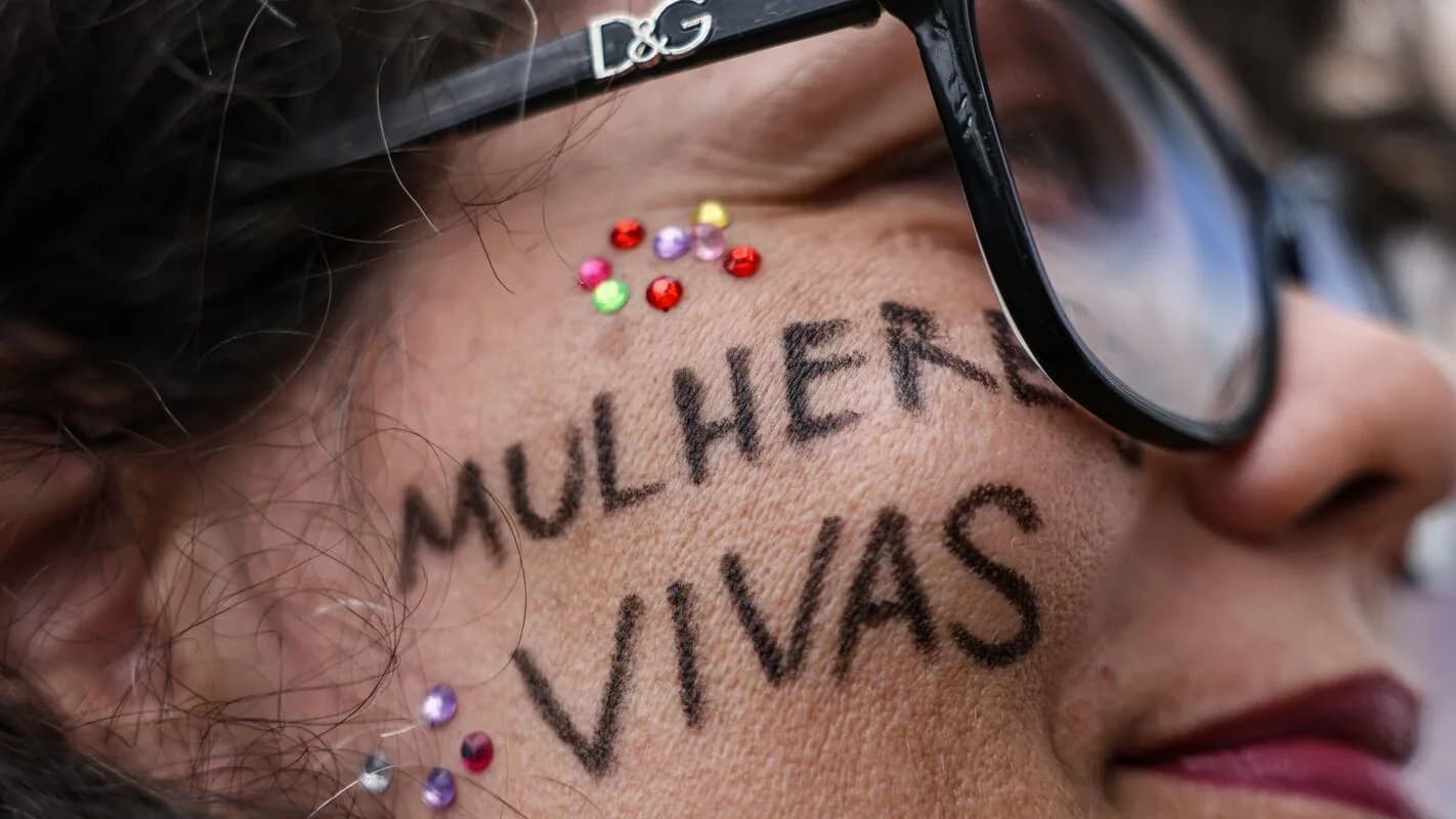 Rosto de mulher com a frase mulher viva escrita no rosto, em protesto contra a violência de gênero