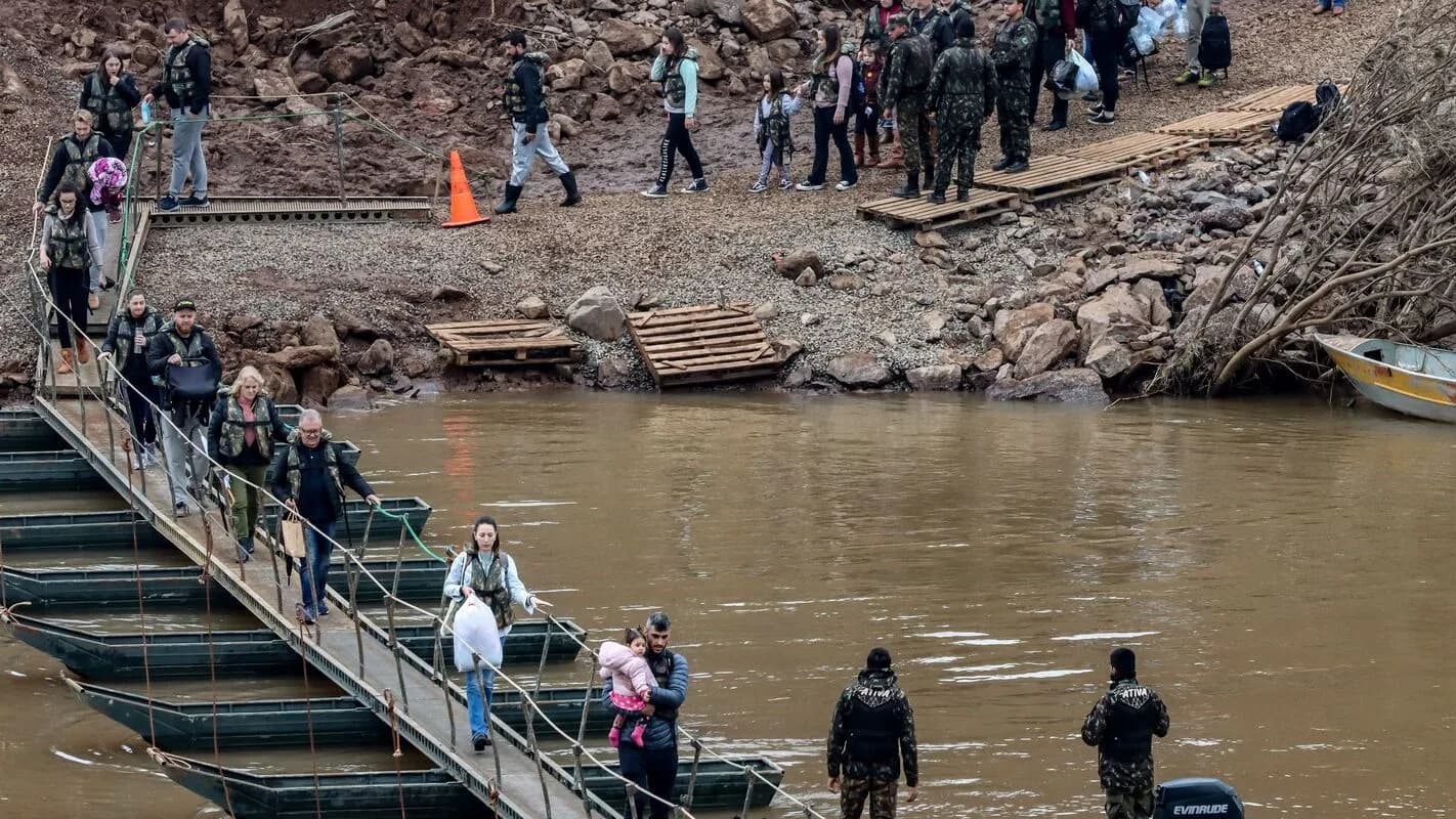 Militares do Exército ajudam moradores a atravessar área alagada no Rio Grande do Sul, foto de arquivo da enchente de 2024