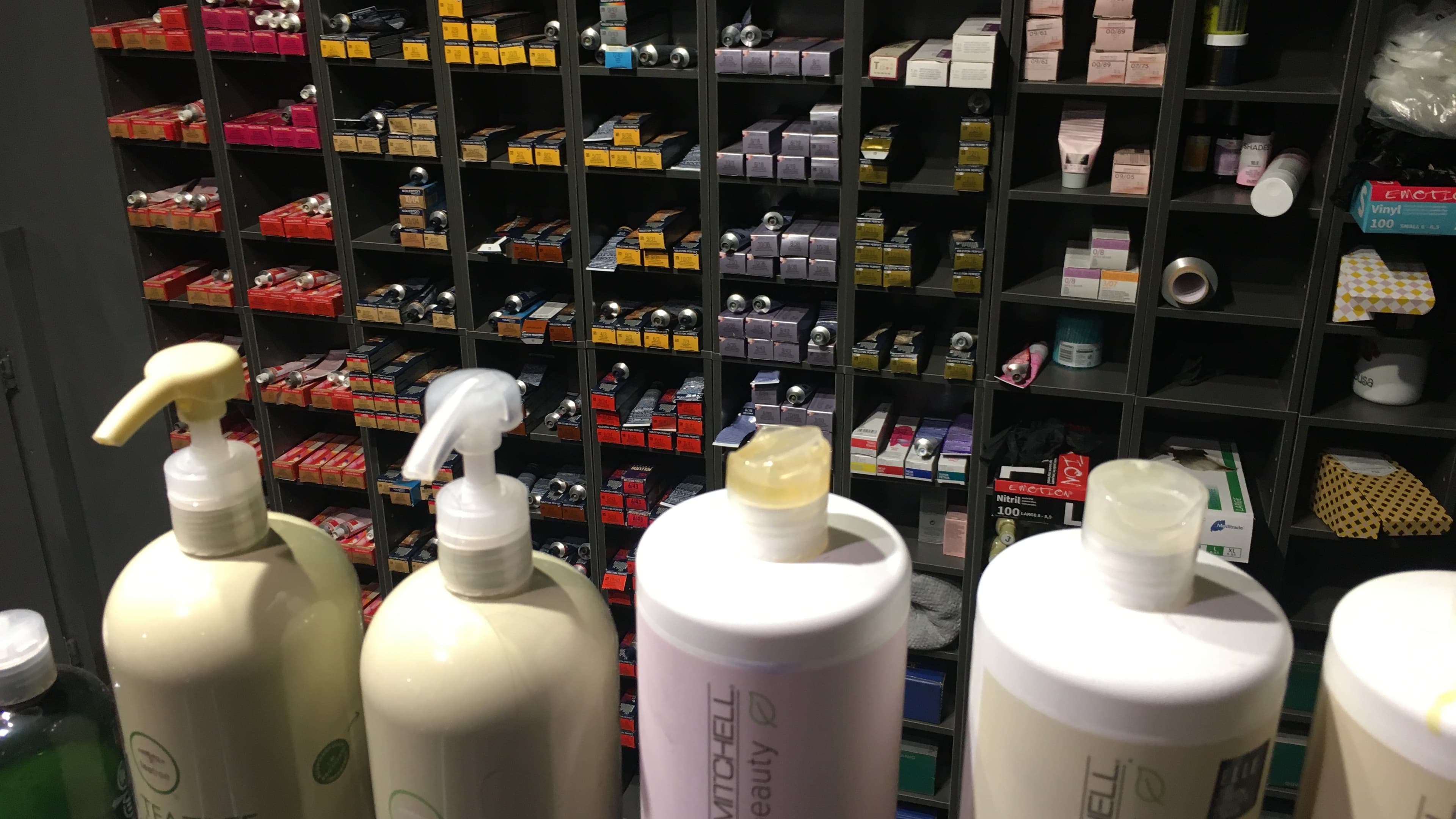Prateleira de salão de beleza com frascos de produtos de cabelo e cosméticos, foto ilustrativa