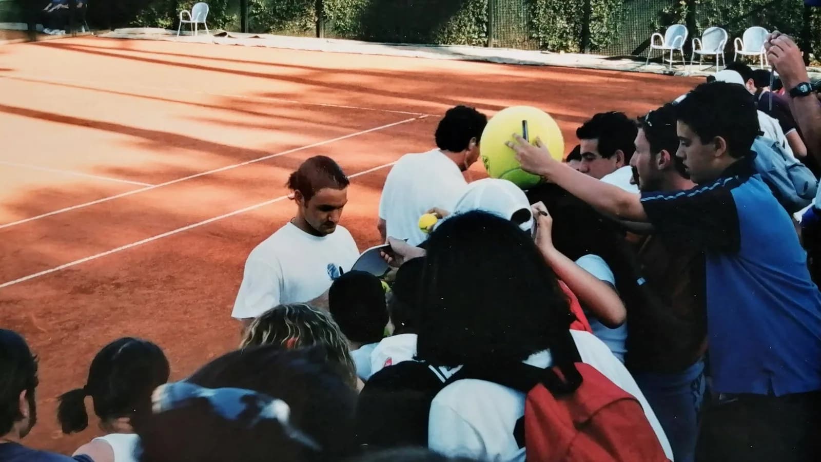 Roger Federer autografa itens para torcedores em quadra de tênis