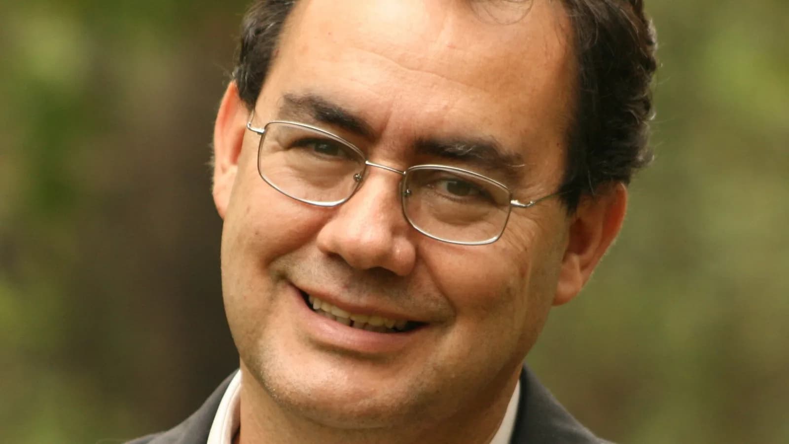 Augusto Cury sorrindo, de óculos e blazer, em foto de arquivo