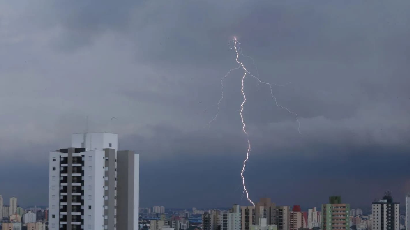 Raio atinge o céu de São Paulo durante tempestade, com prédios da cidade em primeiro plano