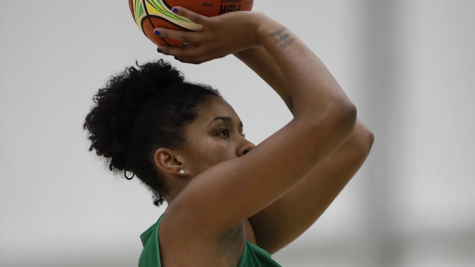 Jogadora da seleção brasileira de basquete feminino arremessa a bola durante treino