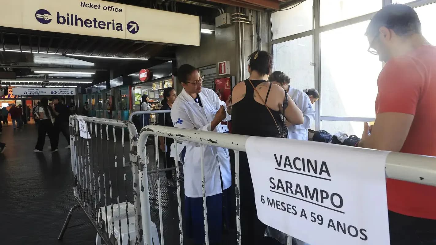 Profissional de saúde atende pessoas em posto de vacinação contra o sarampo