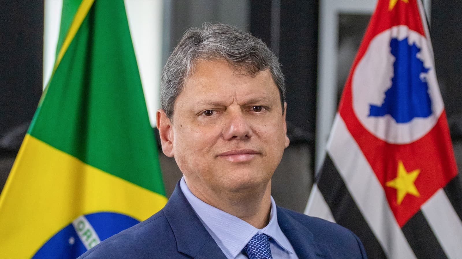 Tarcísio de Freitas em foto oficial como governador de São Paulo, com bandeiras do Brasil e do estado ao fundo